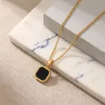 Colar homem dourado com pedra preta em aço inoxidável com medalha.