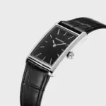 Relógio para homem, com mostrador retangular preto e bracelete em pele preta.
